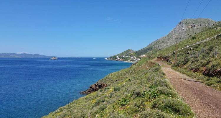 A coastal road with hills and sea views.