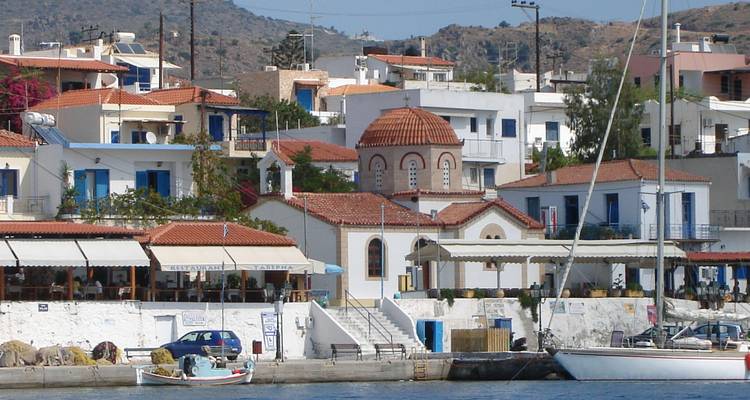 Ville côtière avec des bâtiments blanchis à la chaux et une petite église.