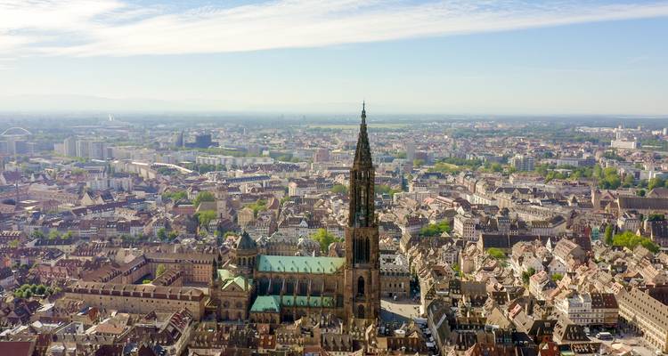 Vue aérienne d'une cathédrale et d'un paysage urbain sous un ciel dégagé.