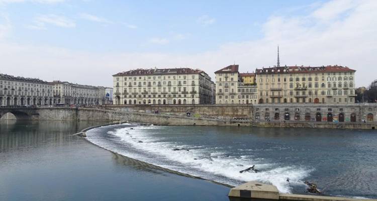 Paysage fluvial avec de grands bâtiments historiques en arrière-plan.