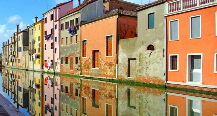 Casas adosadas coloridas reflejándose en un canal.