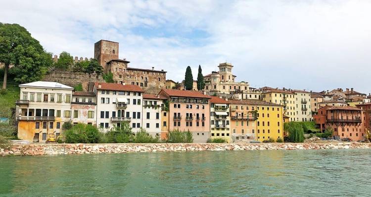 Bunte Gebäude an einem Fluss in einer historischen Stadt.