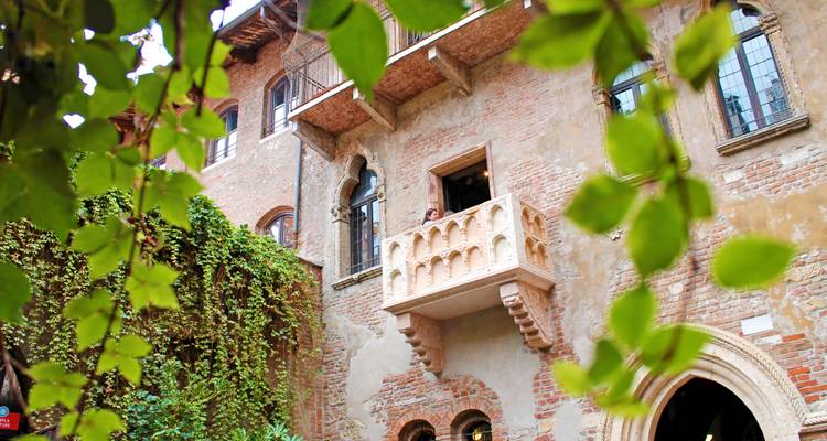 Historisch gebouw met balkon en klimop.