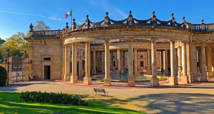 Grande architecture avec une colonnade circulaire et un drapeau italien.