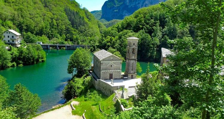Historische Gebäude nahe einem See mit einer malerischen Landschaft.