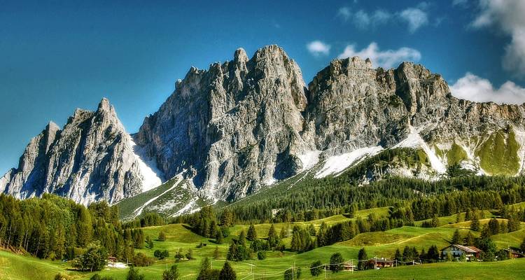 Majestätische Bergkette mit klarem blauen Himmel und üppiger Umgebung.