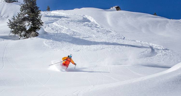 Skiër die verse sporen maakt op een met sneeuw bedekte helling.