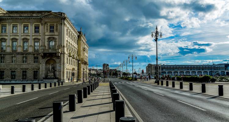 Stedelijke straat met historische gebouwen onder een dramatische lucht.