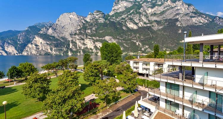 Ein modernes Gebäude mit Panoramablick auf einen See und Berge.