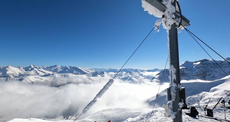 Vue du sommet glacé depuis un télésiège avec brume et collines en contrebas.