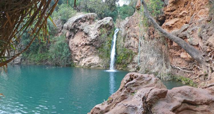 Petite cascade qui se déverse dans un bassin turquoise.