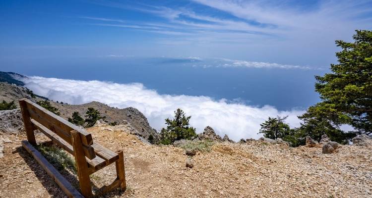 Bergpanorama mit Bank mit Blick über die Wolken.