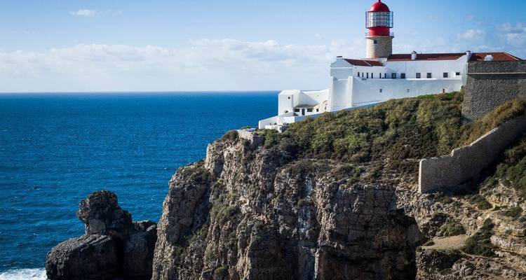 Phare sur une falaise rocheuse avec l'océan en arrière-plan.