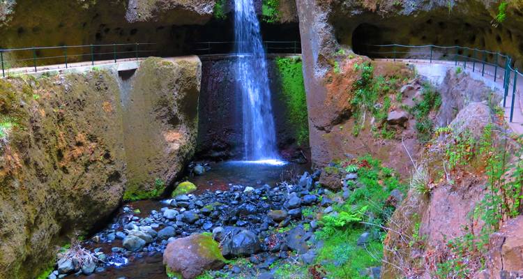 Waterval die stroomt in een door rotsen omgeven poel.