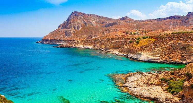 Coastal landscape with turquoise waters and rocky cliffs.