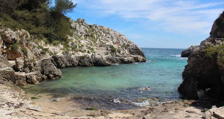 Petite crique rocheuse avec une eau bleue claire.