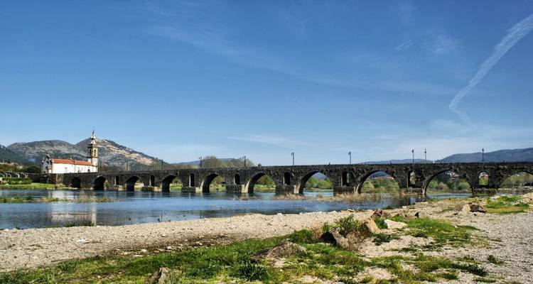 Pont de pierre voûté enjambant une rivière.