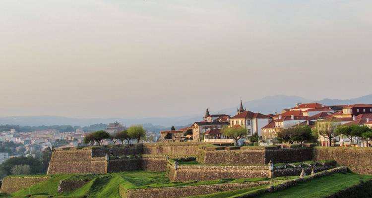 Ruines de forteresse avec ville en arrière-plan.