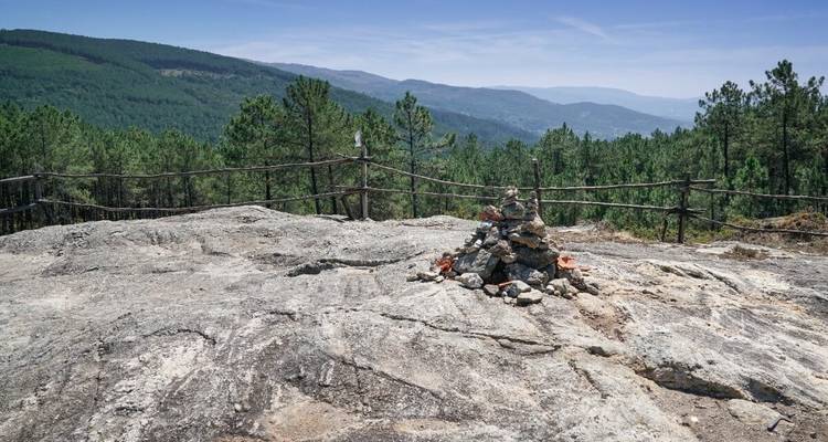 Affleurement rocheux avec vue lointaine sur la forêt et les montagnes.