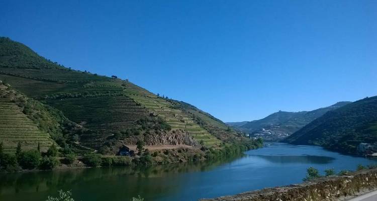 Fluss, der durch Hügel mit terrassierten Landschaften an einem klaren Tag fließt.