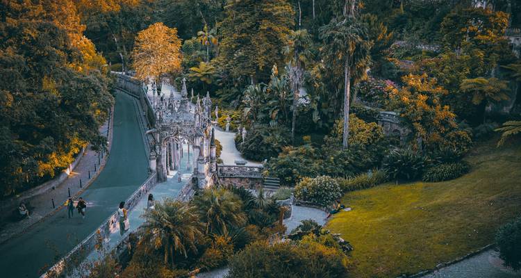 Toeristen genieten van een weelderige tuin met sierlijke details.