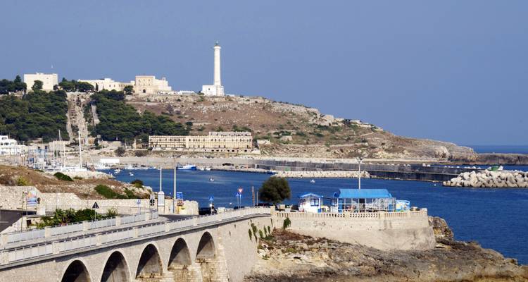 Rotsachtige kustlijn met een verre vuurtoren.