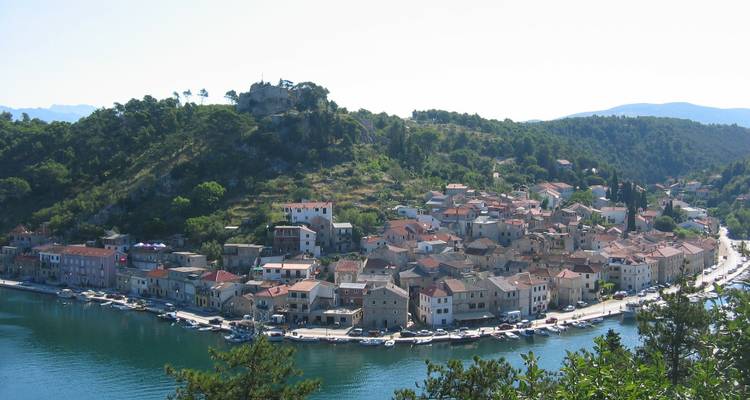 Petit village côtier entouré de collines et d'eau.