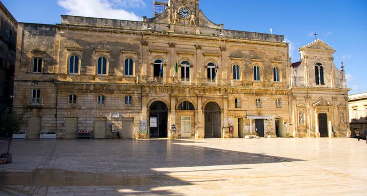Historisch gebouw met een klokkentoren op een groot plein.