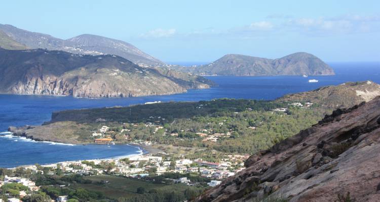 Une vue côtière avec des îles lointaines et une mer bleue.