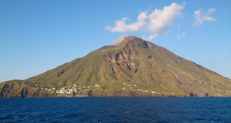 Une île volcanique en forme de cône avec de la fumée qui s'élève du sommet.