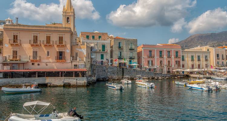 Une charmante ville portuaire avec des bâtiments aux couleurs pastel et de petits bateaux.