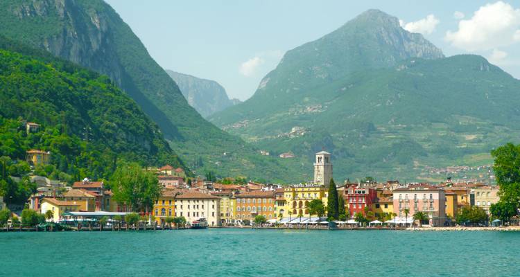 Une ville au bord du lac avec des bâtiments colorés et un arrière-plan montagneux.