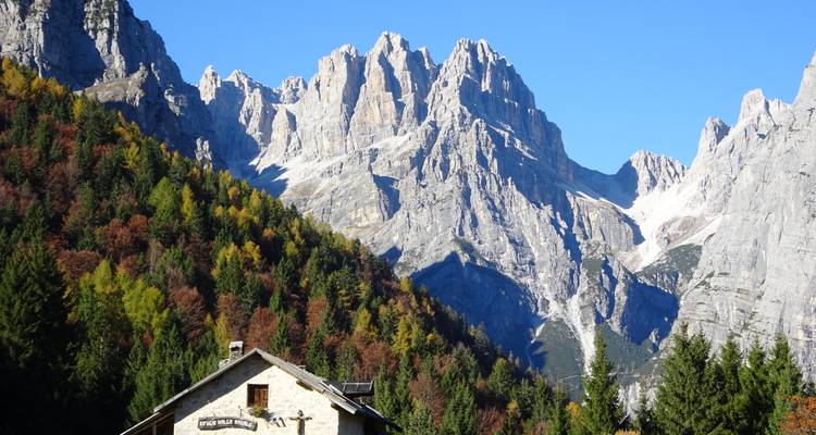 Une cabane près de montagnes rocheuses spectaculaires et de la forêt.