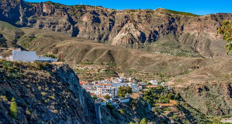 Village nestled in a valley surrounded by steep cliffs.