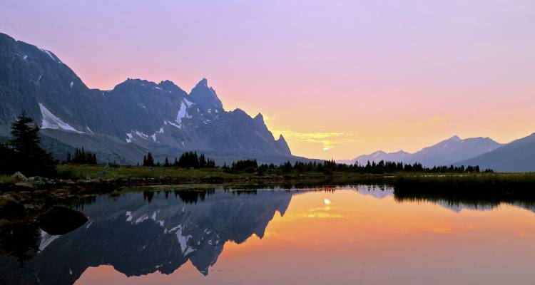 Mountain reflection on a lake at sunrise.