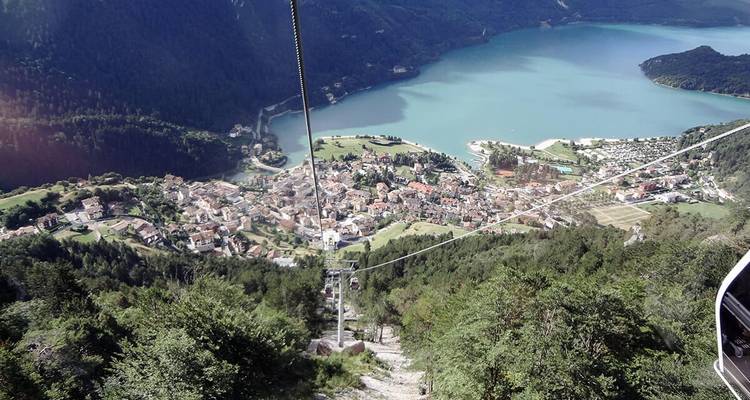 Landschaftsblick aus einer Seilbahn mit Ausblick auf einen See und eine Stadt.