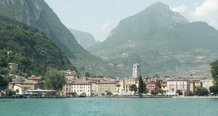 Bunte Stadt am See mit bergiger Kulisse.