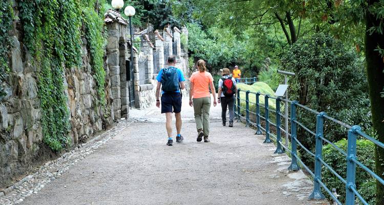 Mensen die lopen op een natuurpad omzoomd met stenen muren.