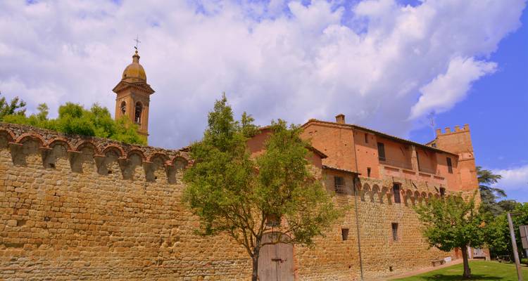 Historic fortified building with a bell tower under a cloudy sky.