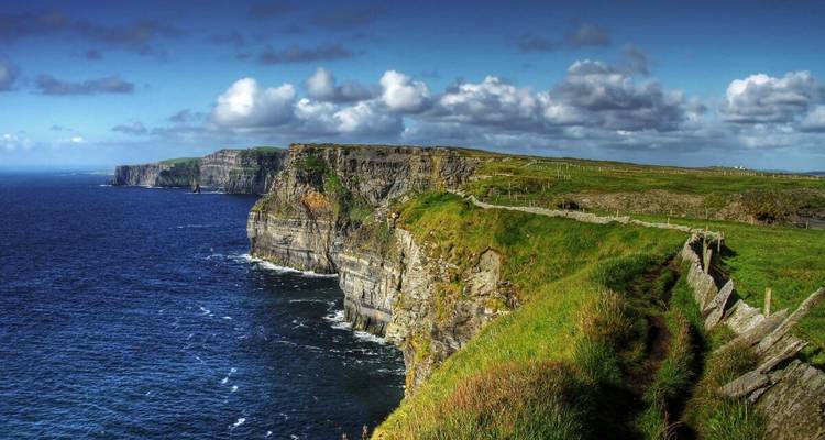 Cliffs over the ocean with clear blue skies.