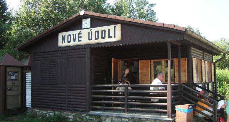 A rustic wooden building with a sign that reads 'Nové Údolí'.