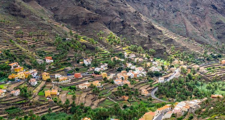 Vallée pittoresque avec agriculture en terrasses et maisons.
