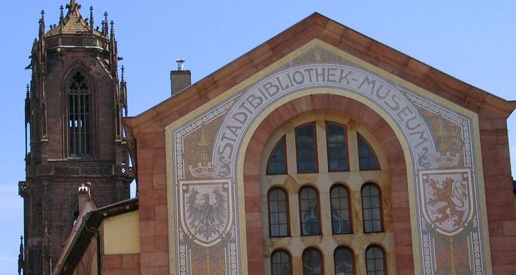 Bâtiment portant l'inscription Stadbibliothek-Museum avec une haute flèche à côté.