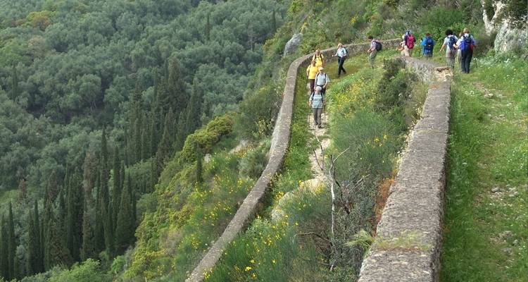 Groupe de randonneurs marchant sur un sentier le long d'une colline.