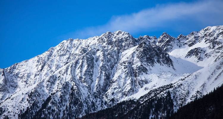 Schneebedeckte Bergkette unter einem klaren blauen Himmel.