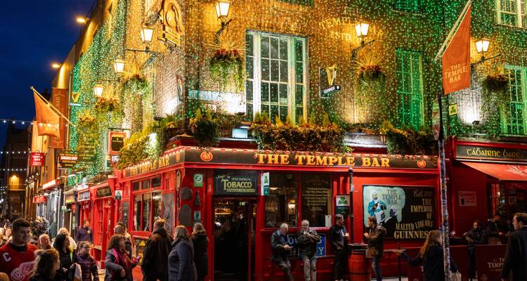 Vibrant night scene of The Temple Bar with people outside.