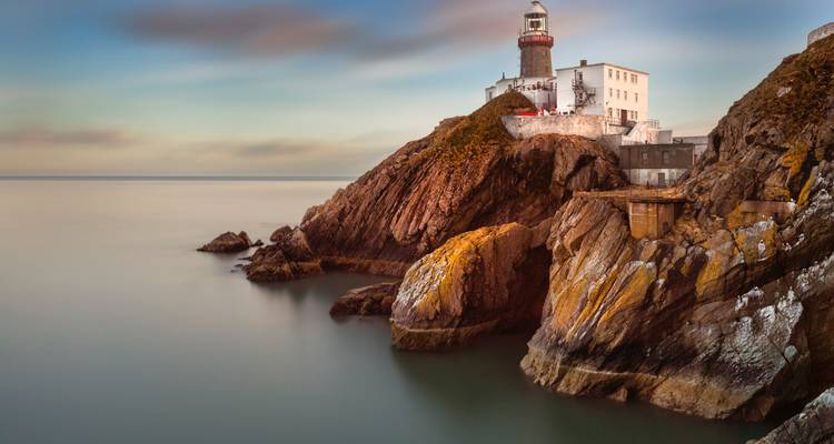Lighthouse on a rocky coastline with a long exposure effect.