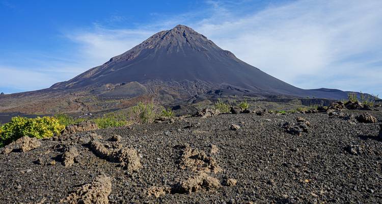 Majestic dark volcanic cone of Pico do Fogo rising above barren lava fields