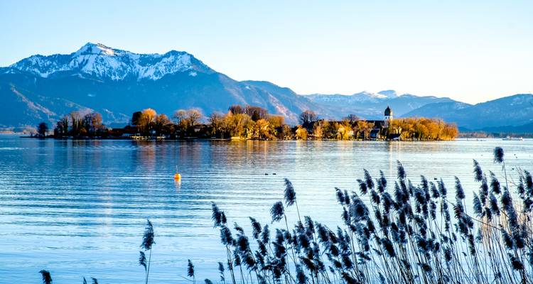 Un lac avec des reflets de montagnes et une île.