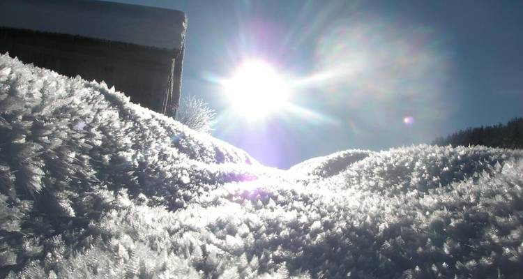 Sunlight reflecting on snow-capped mounds.